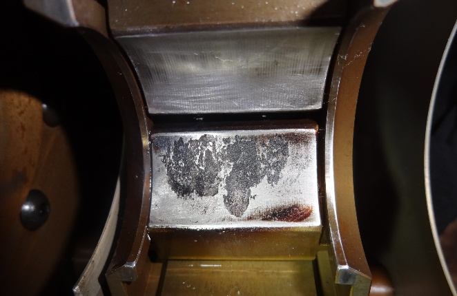 IHI TX-A 2nd-stage bearing pad after carbon removal — babbitt flaking