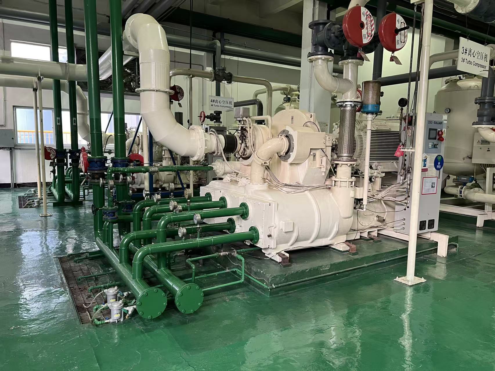 IHI centrifugal air compressor installation in an industrial plant — showing the typical green piping, white bull-gear casing and control panel layout found across T2A, TXA, TRA, TRE and TRX series
