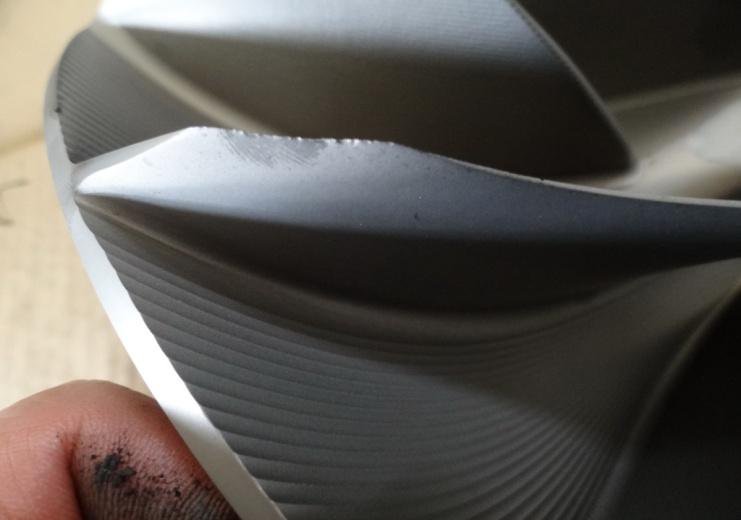 Compressor impeller leading edge with progressive material loss from erosion and cavitation